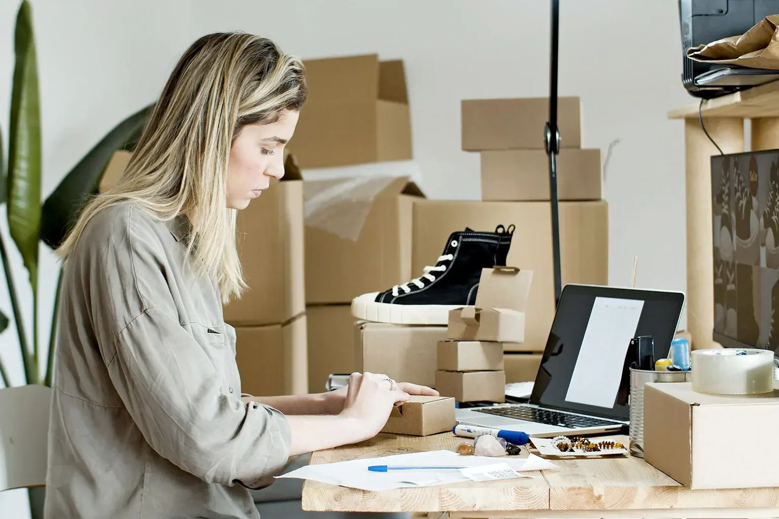 A small business owner preparing a parcel at a packing desk